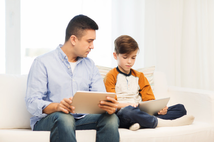 Father and son using tablets
